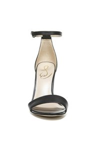 Zwarte hoge hak sandaal met een open teenontwerp, voorzien van een brede strap over de voorkant en een dunne enkelband. Gladde leren textuur.