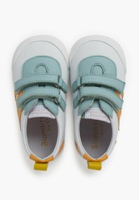 Scarpe per bambini in pelle bianca con accenti turchese e arancione, dotate di doppie strap in Velcro e suola in gomma testurizzata. Design con punta rotonda.