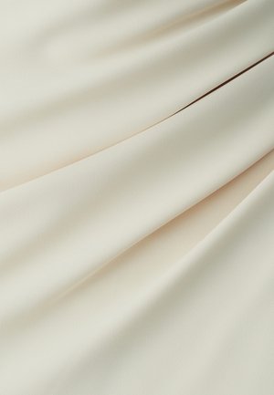 Tela suave y ligera con una textura lisa en color blanco roto, que presenta caídas suaves y un brillo sutil.