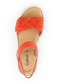 Orange ruskindssandal med et flettet stropdesign, åben tå-stil, polstret sål og justerbar bagstrop. Letvægts og fleksibel.