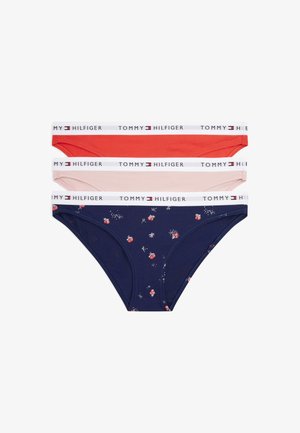 Three cotton bikini briefs in red, light pink, and navy with floral print, featuring white elastic waistbands branded "Tommy Hilfiger."