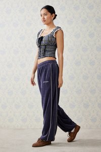 Karo kratki top s puf rukavima i čipkastim obrubom, uparen s tamnoljubičastim velur duksericama s bijelim pipingom. Smeđe mokasine.