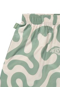 Lette shorts i beige med et bølgende, grønt abstrakt mønster. Elastisk liv med subtil merkevaretag, glatt stofftekstur.