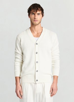 Cardigan bianco lavorato a maglia con scollo a V e maniche lunghe. Presenta grandi bottoni argentati, polsini a coste e un motivo testurizzato su tutta la superficie.