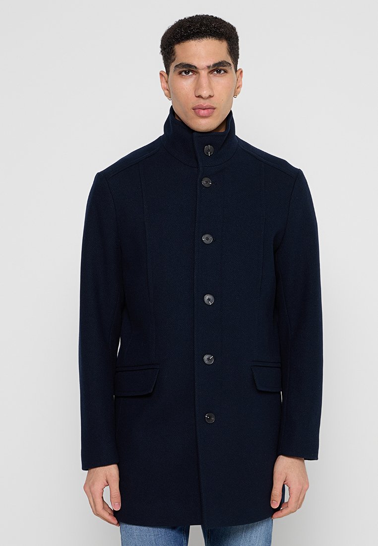 Marineblauwe wollen jas met een hoge kraag, front met zes knopen en twee zijzakken; gestructureerd ontwerp met een textuur afwerking.