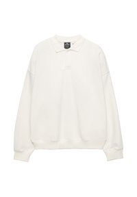 Pulover bej deschis cu guler polo, mâneci lungi și manșete cu margine ondulată. Material moale, croială lejeră, având o placket cu trei nasturi.
