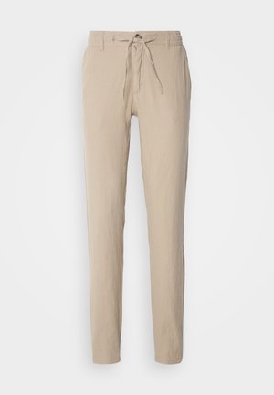 Beige Leinenhose mit geradem Schnitt, elastischem Bund mit Kordelzug und zwei Seitentaschen. Glatte Textur und minimalistisches Design.