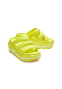Neon gele platform slide sandalen met drie gewatteerde banden en een witte golvende zool, weergegeven tegen een witte achtergrond.