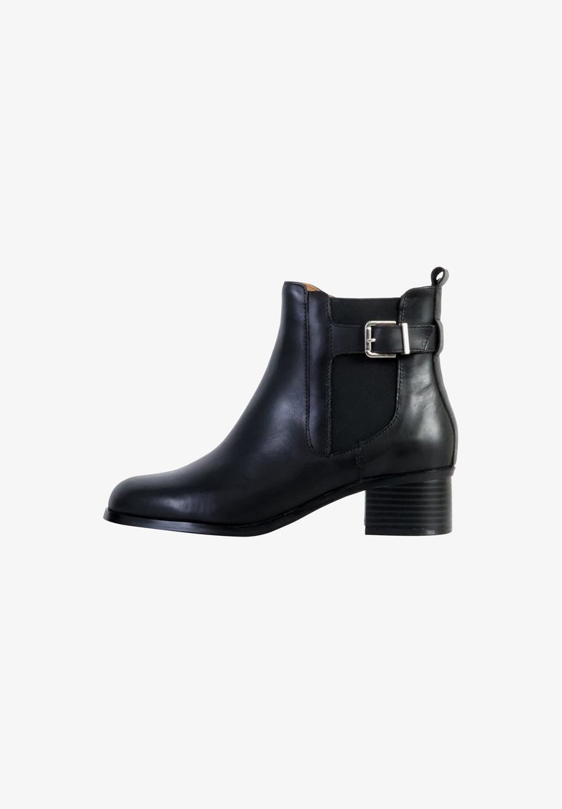 Botte cheville en cuir noir avec un bout arrondi, des panneaux latéraux élastiques et une boucle décorative en argent. Elle présente un talon bas empilé.