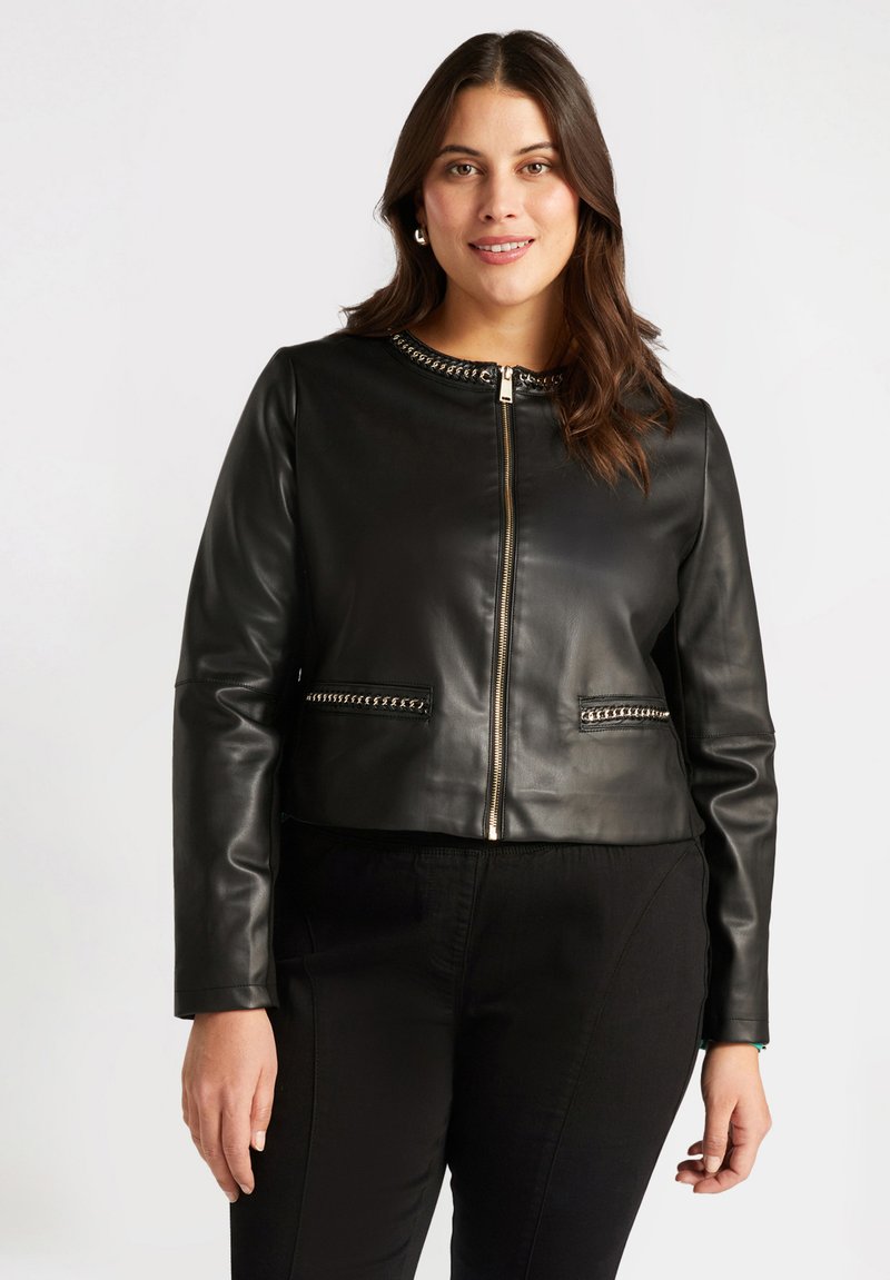 Chaqueta corta de cuero negra con cierre con cremallera en la parte delantera, cuello adornado y detalles en tono plateado en los bolsillos. Textura lisa, diseño ajustado.