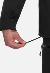Black outerwear with a smooth texture, featuring a drawstring adjustment. A hand grips the cord near the hem, showcasing functionality.
