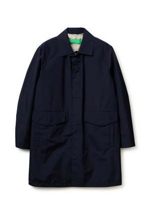 Cappotto lungo blu navy con colletto appuntito, bottoni frontali nascosti e due grandi tasche a patta frontali, steso su sfondo bianco.