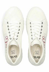 Zapatillas blancas con punta redonda, suela plana y diseño de cordones. Características de material suave y gráfico decorativo de corazón rojo y gris en el costado.