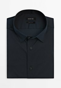 Granatowa koszula z kołnierzykiem, z zapięciem na guziki i gładką teksturą. Etykieta mówi "Massimo Dutti" oraz "Wyprodukowano w Turcji."