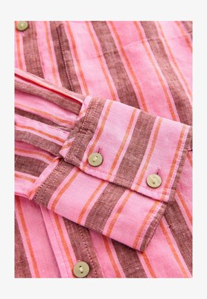 Gestreept shirt met roze en bruine tinten, met twee knopen op de manchetten en een zachte, textuur gevarieerde stof. Langs mouwen zijn zichtbaar.