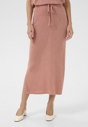 Gonna midi a maglia rosa con vita regolabile e spacco laterale, caratterizzata da una sottile texture luccicante. Abbinata a scarpe con tacco a blocco bianche.