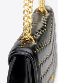 Czarna skórzana torebka z złotymi ćwiekami i złotym łańcuszkowym paskiem. Charakteryzuje się pikowaną teksturą i usztywnionym kształtem, podkreślającym nowoczesny design.