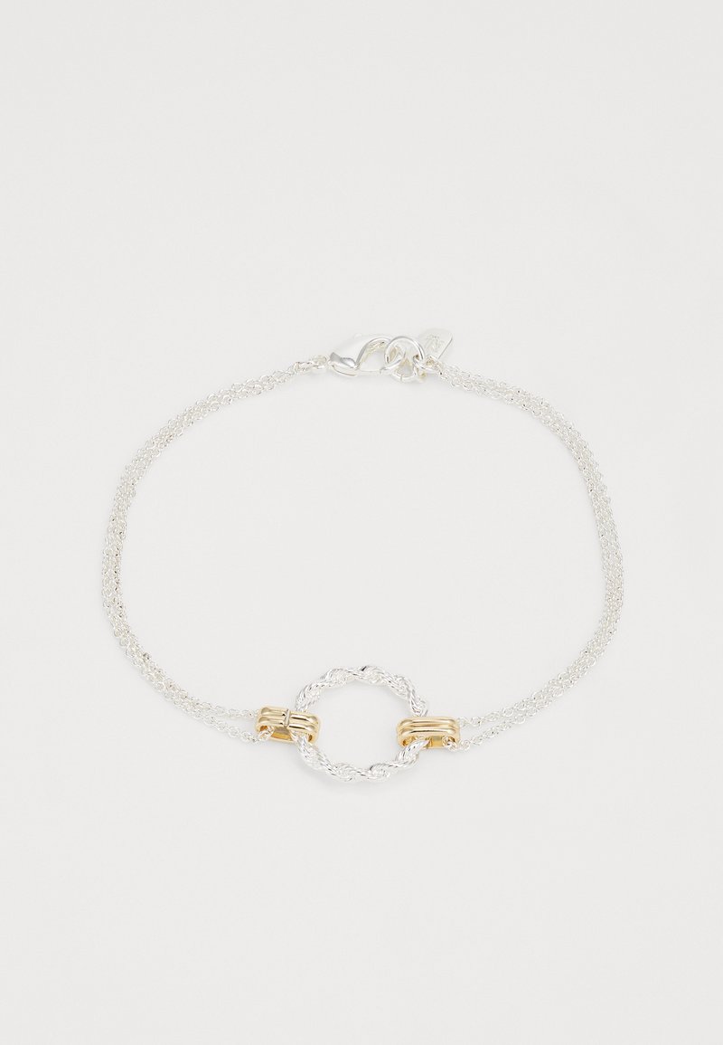 Pulseira de prata com duas correntes, apresentando um realce circular dourado torcido e fecho com clasp de lagosta. Textura suave e design delicado.