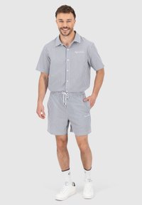 Stripete kortermet skjorte og matchende shorts i marineblå og hvit, med knappestolpe foran, elastisk midje og sidelommer.