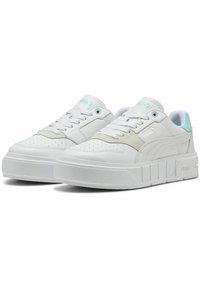 Fehér sportcipők sima bőr felsőrésszel, texturált részletekkel, vastag platformtalppal, valamint világoskék díszítéssel a nyelvén és a sarkán.