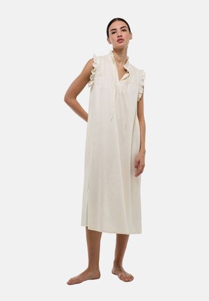 Robe sans manches de couleur crème avec des épaules froncées, un plastron à boutons et une coupe libre jusqu'aux genoux, réalisée dans un tissu léger.