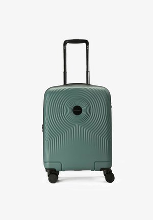 Valigia rigida di colore teal con una texture ondulata, accenti neri, una maniglia telescopica e quattro ruote per la mobilità.