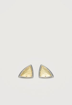 Paire de boucles d'oreilles triangulaires avec des centres en or martelé encadrés par des bords en argent lisse sur un fond clair uni.