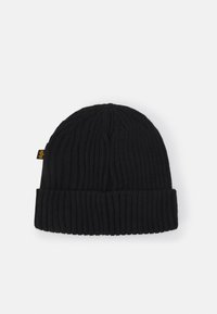Knitted black beanie with ribbed texture and a turned-up cuff, featuring a small yellow tag on the side.