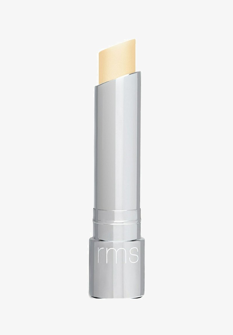 Duidelijke lippenbalsemstick in een zilveren behuizing, met een licht afgeronde, bleke beige top. De merknaam "rms" is op de basis gebosseerd.