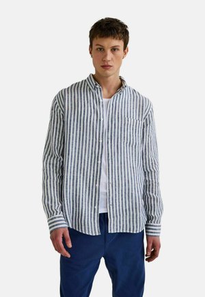 Chemise à rayures bleu clair et blanche, à manches longues, avec poche sur la poitrine et coupe décontractée, associée à un pantalon bleu marine.