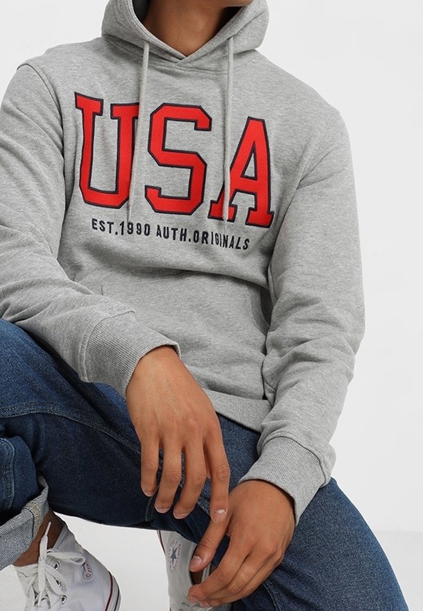 Sudadera gris con llamativo lettering rojo "USA" y el texto "EST.1990 AUTH.ORIGINALS". Tela de mezcla de algodón, con capucha ajustable y puños acanalados.