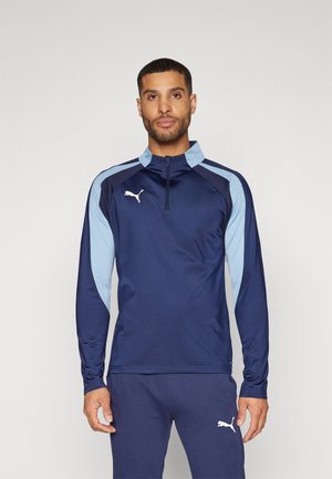 Marinblå langærmet atletisk top med lyseblå accenter, høj krave og halvlynlås-design. Har et hvidt logo på brystet og en glat tekstur.
