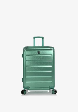 Valise rigide verte avec poignée télescopique et quatre roues multidirectionnelles vue de face sur fond blanc.