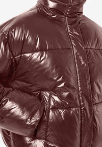 Bordo spalvos pūsta striukė su blizgiu paviršiumi, aukšta apykakle ir horizontaliu siuvinėjimo raštu; turi šonines kišenes ir elegantišką dizainą.