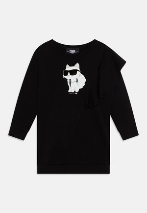 Sweatshirt noir à manches longues, avec un motif imprimé sur le devant représentant un chat en dessin animé portant des lunettes de soleil, et un accent froncé sur le côté gauche.