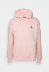 Hoodie rosa chiaro realizzato in tessuto morbido. Presenta una tasca frontale e un logo Jumpman nero sul lato sinistro del petto. Vestibilità standard con cappuccio regolabile tramite lacci.