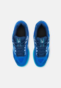 Baskets de sport bleues avec tige en maille, col rembourré et semelle en caoutchouc. Présentent des accents blancs et turquoise, ainsi qu'un design à lacets.