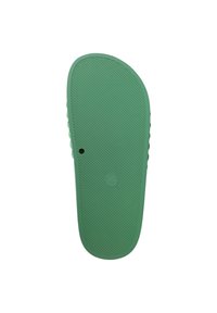 Suola di sandalo in gomma verde con superficie testurizzata, caratterizzata da scanalature orizzontali e scanalature laterali. Dettaglio del logo circolare visibile vicino al centro.