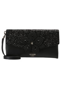 Portefeuille noir avec rabat supérieur pailleté, orné d'un détail floral et d'une bandoulière amovible. Présente un logo à l'avant. Texture lisse sur l'ensemble.