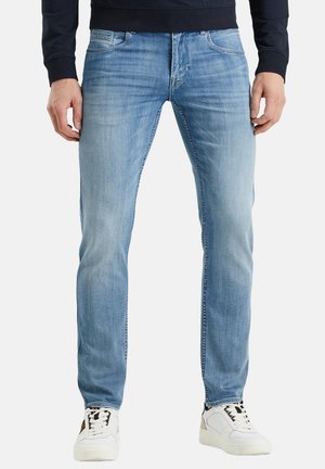 Lichtblauwe denim jeans met een slim fit, voorzien van een klassiek vijf-pocket ontwerp en subtiele vervaging. Gepaard met witte sneakers.