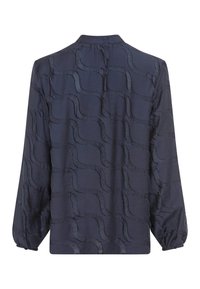 Blusa a maniche lunghe di colore blu navy con un motivo ondulato testurizzato, colletto arrotondato e polsini elasticizzati. Realizzata in tessuto leggero e liscio.