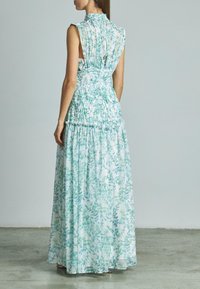 Maxikleid mit taillierter Brustpartie, gerafftem Bund und einem floralen Muster in Grün- und Blautönen auf weißem Hintergrund. Weicher, leichter Stoff.