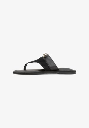Schwarze Flip-Flop-Sandale mit Wildlederobermaterial und Lederfußbett. Verfügt über einen Zehenriemen und goldfarbene Hardwareakzente. Flache Sohle.