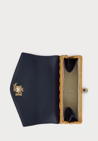 Mornarska kožna novčanica s pletenim bež detaljima, s zlatnom kopčom, otvorena da otkrije strukturirani interijer s teksturiranom oblogom.