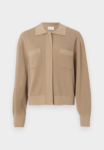 Beige ribbad stickad cardigan med krage, frontknäppning och två bröstfickor. Långa ärmar med ribbade manschetter.