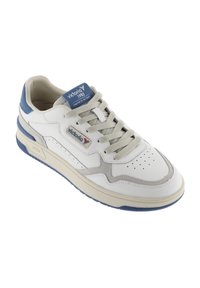 Zapatilla de cuero blanca y gris con acentos azules, puntera perforada, entresuela texturizada y cordones planos, que presenta una etiqueta de logo en la lengüeta.