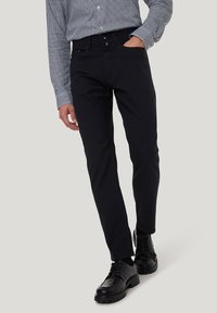 Schwarze, schmal geschnittene Hose aus einem Baumwollmix, mit glatter Textur, zwei vorderen Taschen und einem klassischen Bund mit Gürtelschlaufen.