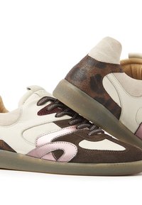 Sneakers in beige, brown, and burgundy leather with a textured upper, featuring curved design lines, rounded toe, and rubber sole.