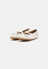 Bailarinas de cuero blanco con punta redonda, tira delgada en el tobillo y detalles de lazo decorativos. Suela tan ligeramente flexible. Textura suave.