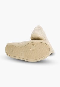 Světle béžové slip-on boty s textilním svrškem a gumovou podešví. Obsahují texturovaný design a zaoblenou špičku. Podešev má vzorovaný grip.